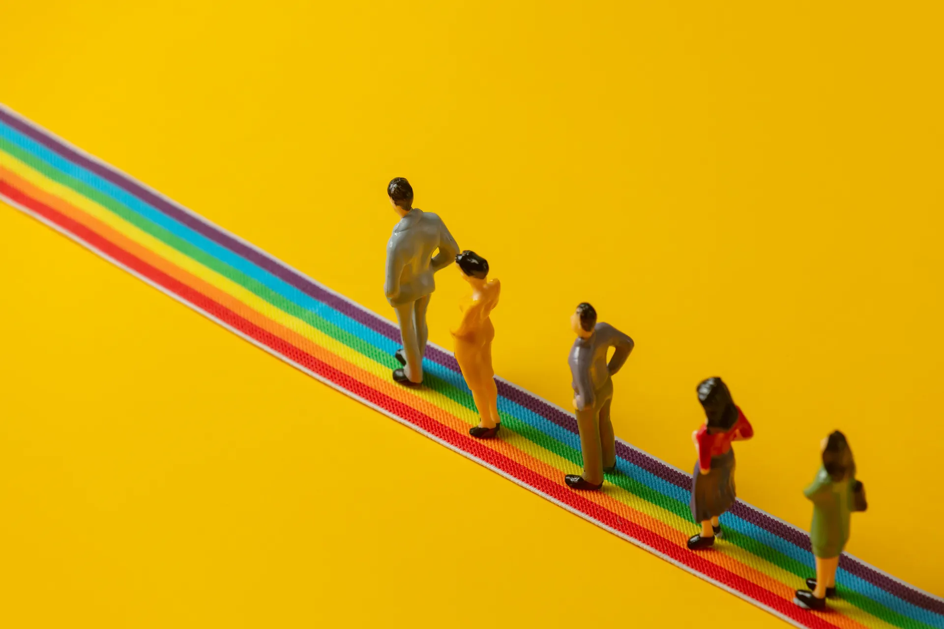 Figuras miniatura em arco-íris representando diversidade de perfis de usuário e empatia